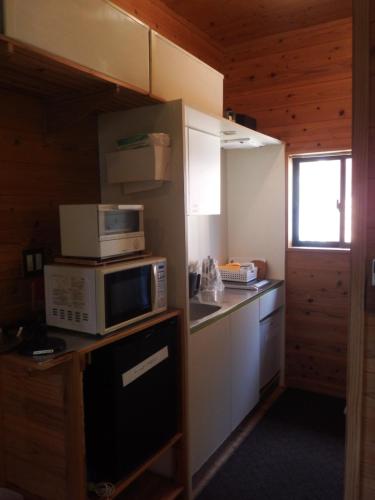 a kitchen with two microwaves and a microwave on a counter at Green Cottage ＭＭ in Yakushima