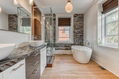a bathroom with two sinks and a large tub at Le Manoir des Braves - Piscine in Quebec City