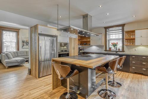 a kitchen with a large island with bar stools at Le Manoir des Braves - Piscine in Quebec City