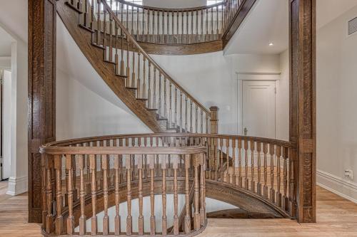 a wooden spiral staircase in a home with at Le Manoir des Braves - Piscine in Quebec City