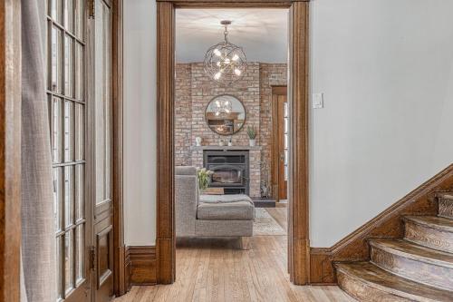 a mirror in a hallway with a chair and a fireplace at Le Manoir des Braves - Piscine in Quebec City