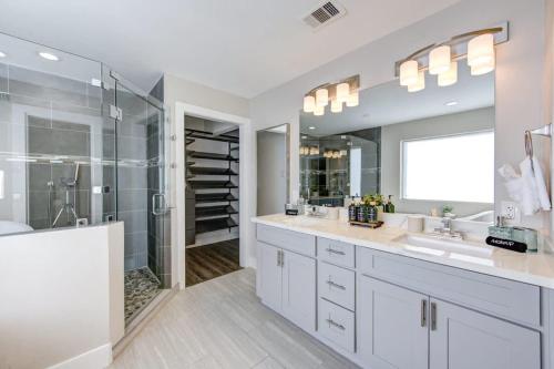 a white bathroom with two sinks and a shower at Ultimate Getaway Explore Katy & Houston in Style in Katy