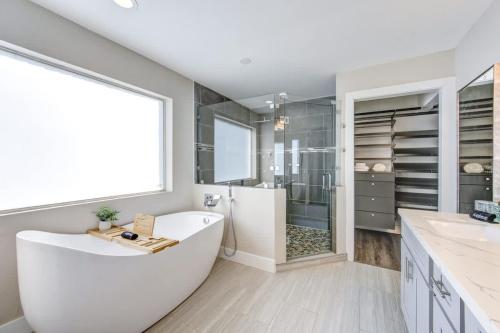 a bathroom with a large white tub and a shower at Ultimate Getaway Explore Katy & Houston in Style in Katy
