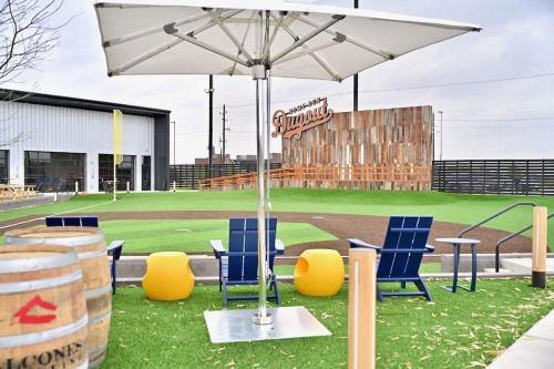 a baseball field with blue chairs and an umbrella at Ultimate Getaway Explore Katy & Houston in Style in Katy