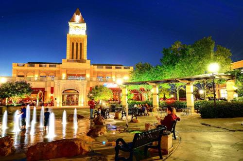 a building with a clock tower and a fountain at Ultimate Getaway Explore Katy & Houston in Style in Katy