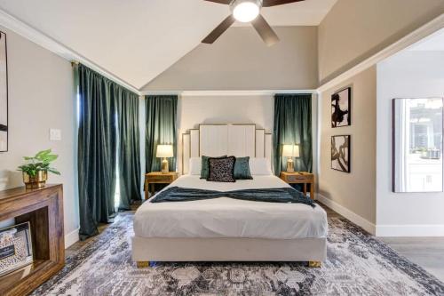 a bedroom with a large bed with green curtains at Ultimate Getaway Explore Katy & Houston in Style in Katy