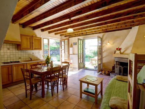 une cuisine et une salle à manger avec une table et des chaises dans l'établissement Gîte rural avec cheminée, salle de jeux, espace télétravail et accès direct aux sentiers de randonnée - FR-1-496-127, à La Versanne