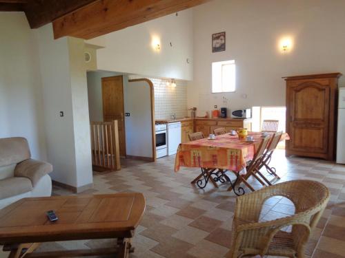 une cuisine et un salon avec une table et des chaises dans l'établissement Gîte Lumineux avec Terrain Privatif et Terrasse - Idéal pour Activités de Plein Air ! - FR-1-496-145, à Chuyer