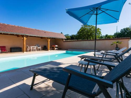 - un groupe de chaises et un parasol à côté de la piscine dans l'établissement Maison périgourdine avec piscine chauffée, jardin et équipements enfants, proche du Bugue - FR-1-616-115, au Bugue