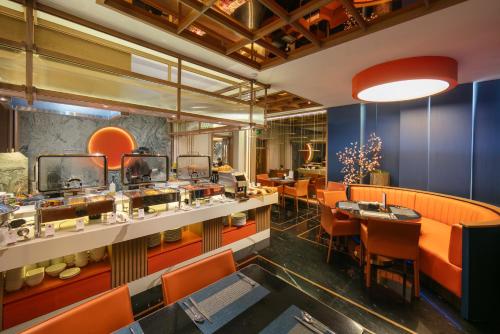 a dining room with orange chairs and tables at Aurora Oriental Hotel in Hanoi