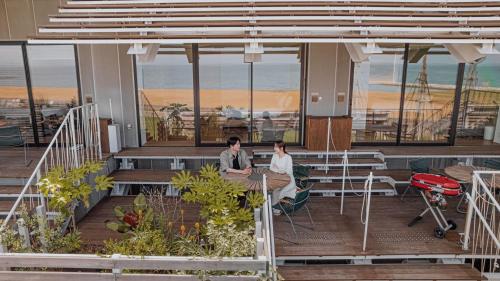 two people sitting at a table in a building at そらすな Beach Side Resort Hotel in Yukuhashi