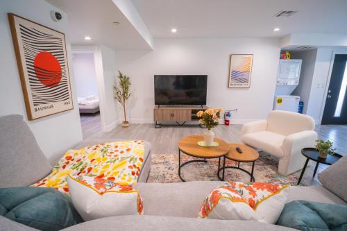 a living room with a couch and a tv at Stylish Private Ensuite Room near USC in Los Angeles