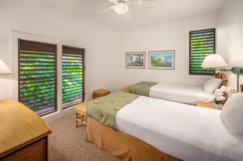 a bedroom with two beds and two windows at Kiahuna Plantation Resort Kauai by OUTRIGGER in Koloa