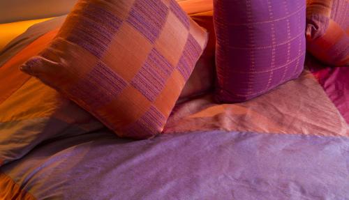 a close up of a bed with a pillow and pillows at Clingendael Hotel in Digana