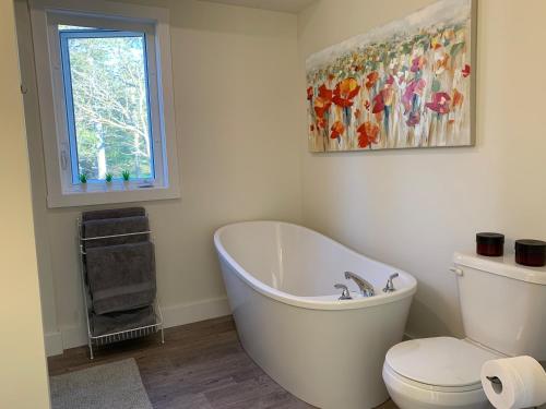 bagno con vasca, servizi igienici e finestra di Whitecaps Summit Beach House 