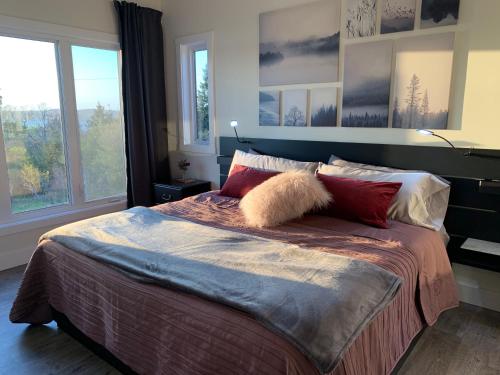 una camera da letto con un letto grande con cuscini sopra di Whitecaps Summit Beach House 