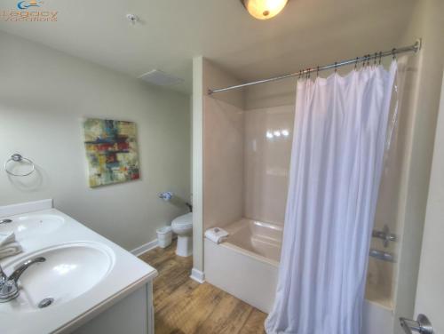 a bathroom with a white shower curtain and a sink at 12th Floor Bchfront Condo-Amazing Views! Sleeps 8! in Navarre