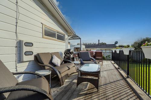 a patio with a couch and chairs and a table at Hosts on the Coast Cookies Cupboard in Pauanui