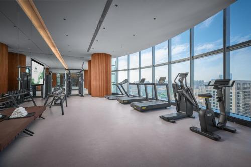a gym with treadmills and ellipticals in a building at MaxX by Steigenberger Harbour-view Qingdao in Qingdao