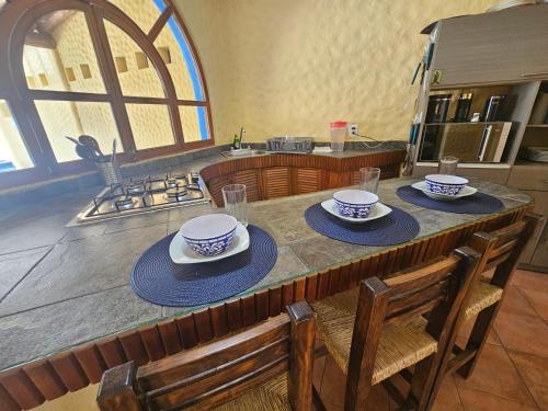 a kitchen with a table with bowls and plates on it at Zihua 6bed 3bath Home for 12 with Direct Access to Beach in Zihuatanejo