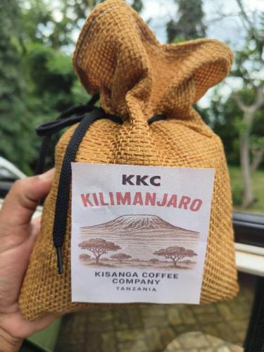 a person holding a bag with a sign on it at Kisanga Homestay in Moshi