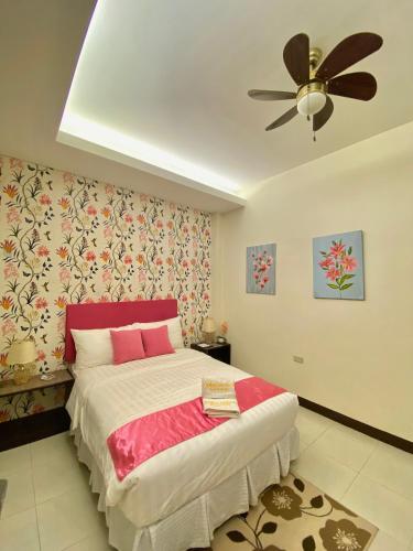 a bedroom with a bed and a ceiling fan at Balai Carmela in Tuguegarao City