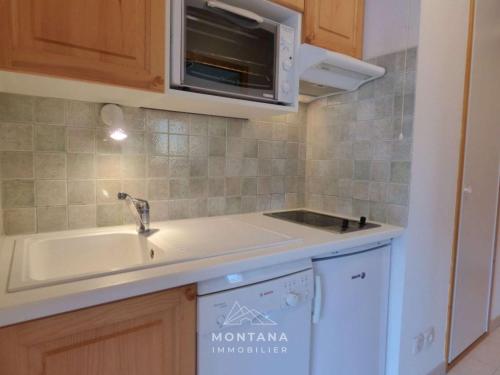 a kitchen with a sink and a microwave at Charmant studio avec cabine - 4 pers - St Jean de Sixt - FR-1-458-223 in Saint-Jean-de-Sixt