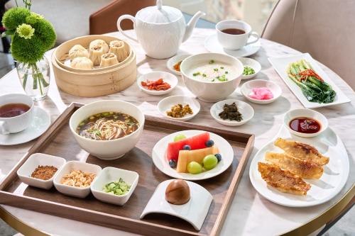 a table with various dishes of food on it at MaxX by Steigenberger Harbour-view Qingdao in Qingdao