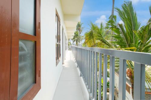 a balcony with a door and palm trees at Super Hotel O D'Rooms in Trivandrum