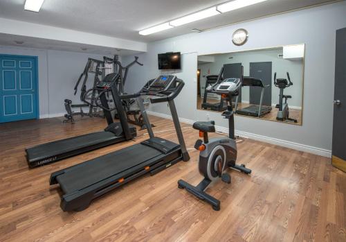 a gym with two tread machines and a mirror at Coast Hinton Hotel in Hinton