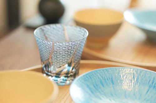 two glass vases sitting on a wooden table at AQUA RESIDENCE Sangenjaya by Tranova in Tokyo