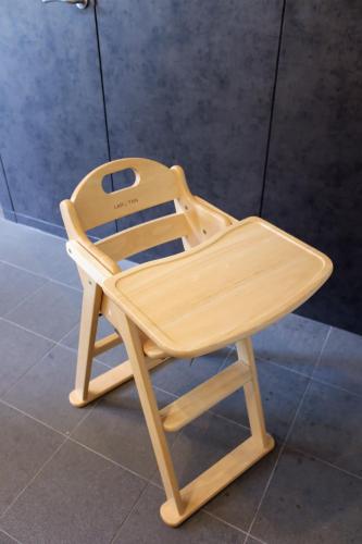 a wooden chair sitting on top of a tile floor at TAKETO STAY Osakajo in Osaka