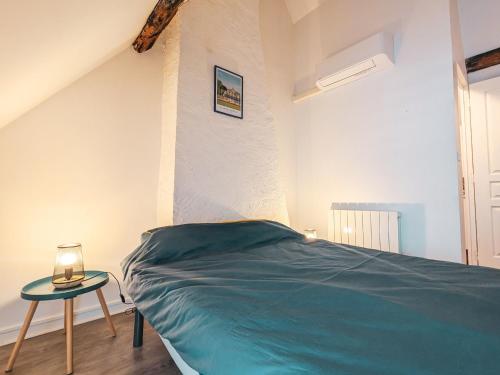 ein Schlafzimmer mit einem Bett und einem Tisch mit einer Lampe in der Unterkunft Maison paisible à Châteauroux avec jardin et parking privé - FR-1-591-759 in Châteauroux