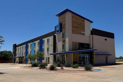 an empty parking lot in front of a building at Days Inn & Suites by Wyndham Colorado City/I-20 in Colorado City