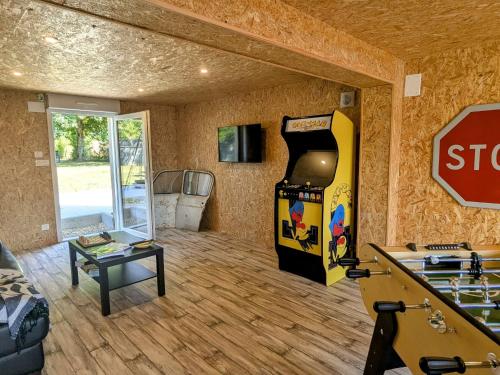 Una sala de estar con una máquina de videojuegos y una señal de stop. en Studio confortable à Vignot, proche Commercy - FR-1-585-182, en Vignot