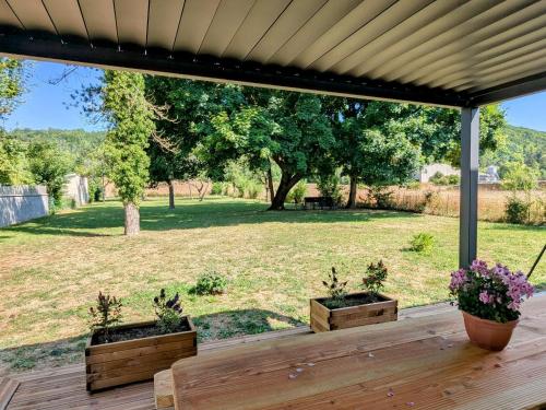 a wooden deck with two potted plants on it at Gîte familial au calme de Vignot - 3 chambres confortables - FR-1-585-181 in Vignot