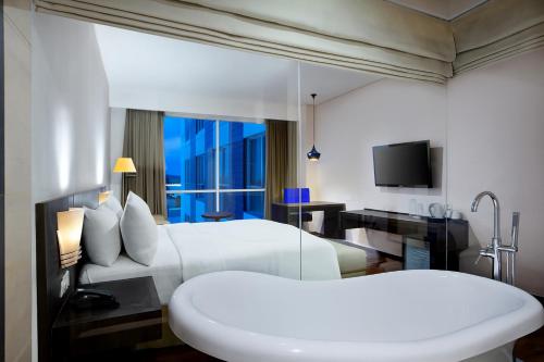 a hotel room with two beds and a television at Aston Jember Hotel & Conference Center in Jember