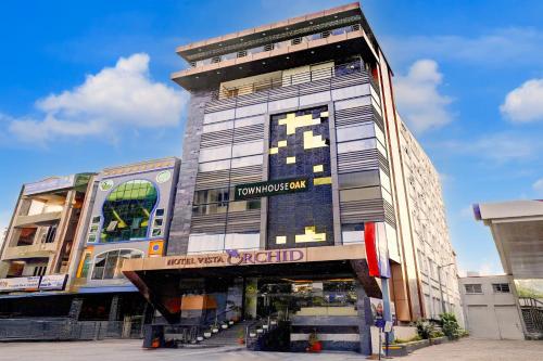 ティルパティにあるTownhouse OAK Hotel Vista Orchidの側面に看板がある大きな建物
