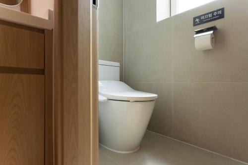 a bathroom with a white toilet in a room at Aank Ryokan Hotel Songtan in Pyeongtaek