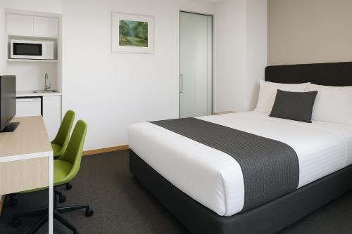a bedroom with a bed and a desk and a computer at Busselton Gale Street Motel & Villas in Busselton