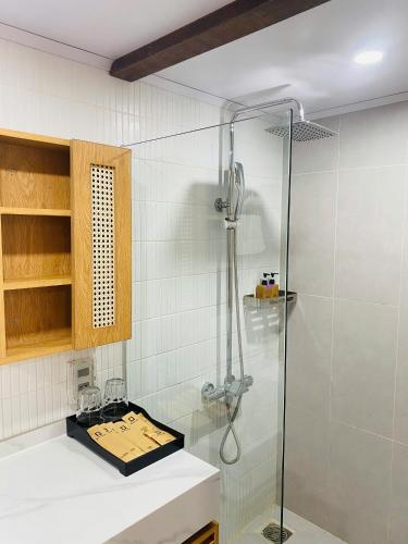 a shower in a bathroom with a sink and a glass shower at Q Village Homestay Đà Lạt in Da Lat