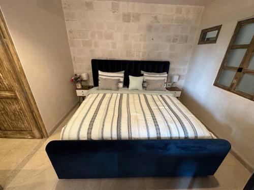 a bedroom with a large bed with a blue headboard at Figata en ValQuirico in Santeagueda