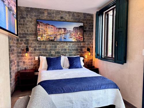 a bedroom with a bed and a painting on the wall at Venezia 2 en ValQuirico in Santeagueda