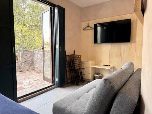 a living room with a couch and a television at Venezia 2 en ValQuirico in Santeagueda