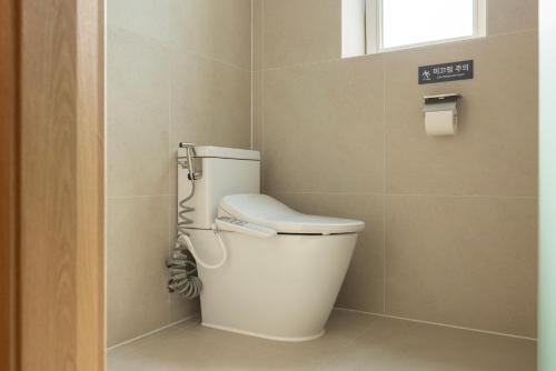 a toilet in a bathroom with a window at Aank Ryokan Hotel Songtan in Pyeongtaek