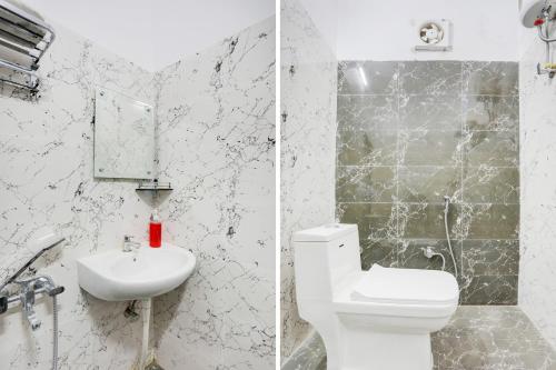 a white bathroom with a toilet and a sink at Hotel O Om Sai inn in Prayagraj