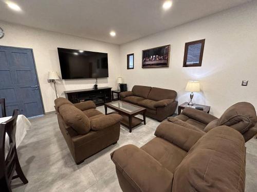 a living room with couches and a flat screen tv at Maximus en ValQuirico in Santeagueda