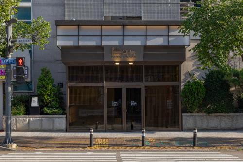 a building with a sign on the front of it at Aank Ryokan Hotel Songtan in Pyeongtaek
