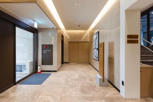 a hallway of a building with a door and a staircase at Aank Ryokan Hotel Songtan in Pyeongtaek