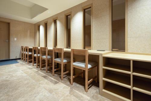 a row of chairs in a dressing room at Aank Ryokan Hotel Songtan in Pyeongtaek